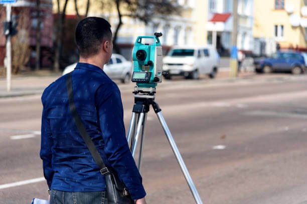Surveyor carrying out a topographical survey using a total station in Essex.