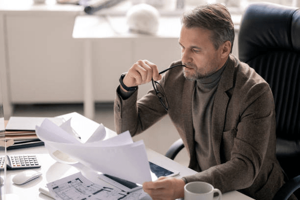 Property consultant reviewing technical drawings and survey documentation as part of a professional building assessment in Essex.